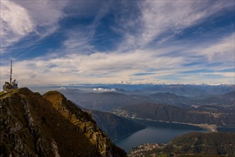 Aerial View over a Beautiful Meteorological and Communication Station on Mountain Peak and Snow Capped Monte Rosa and Lake Lugano in a Sunny Day in Monte Generoso