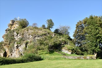Rocky spur with summit cross on the site of the Hunolstein castle ruins