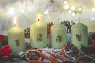 Advent candles surrounded by Christmas decorations