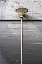 Street lamp in front of a concrete wall