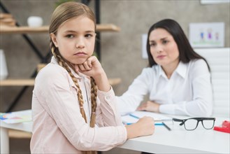 Depressed girl sitting front her female psychologist