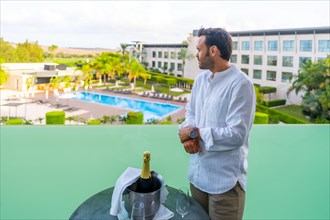 Man preparing a romantic toast with champagne in the hotel terrace