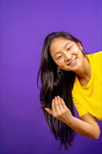 Vertical studio photo with purple background of chinese woman inviting to join with hand