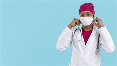 Female doctor adjusting her surgeon mask