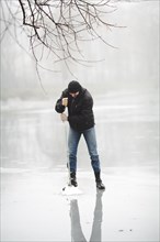 Winter fishing frozen lake with hand drill