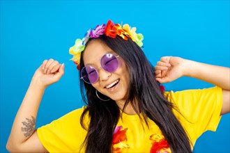 Studio photo with blue background of a Chinese woman with sunglasses and Hawaiian floral crown dancing