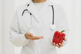Close up doctor with stethoscope bell pepper