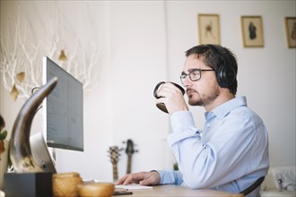 Man working computer drinking