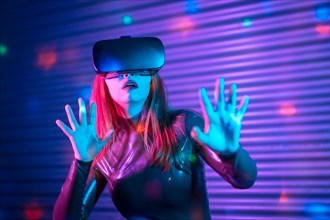Shocked wman during an interactive game with VR goggles in an urban night space with neon lights