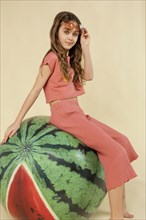 Full shot girl sitting watermelon ball