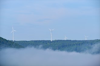 Wind turbines on a hill on a foggy morning