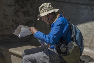 Elderly gentleman reading a city map