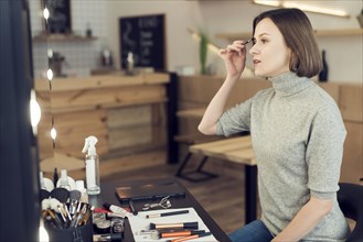 Woman applying eyebrow makeup