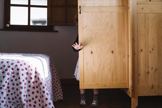 Girl standing wooden cupboard