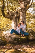 Vertical portrait of casual couple in the nature sitting relaxed