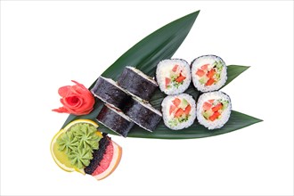 Overhead view of sushi roll with trout with avocado and cucumber served on bamboo leaves