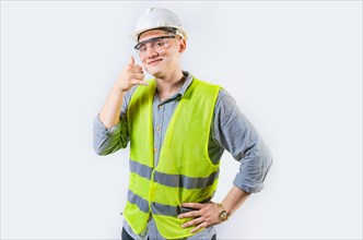 Portrait of young engineer making call gesture isolated. Handsome engineer making call gesture with fingers