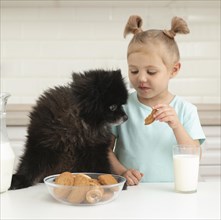 Girl drinking milk playing with dog