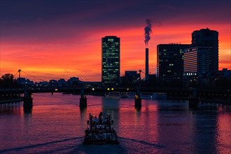 A ship sails along the Main towards Frankfurt's Westhafen harbour in the evening. The office lights are lit up in the Westhafen Tower