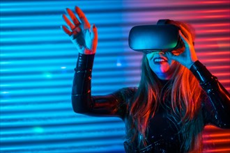 Happy woman using Virtual reality goggles in a futuristic space at night with neon lights