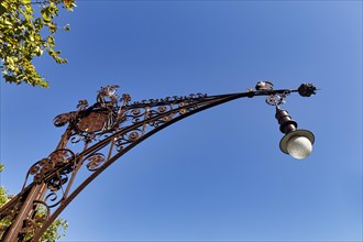 Decorated street lamp in front of a blue sky