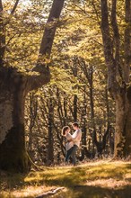 Wide view photo of a couple about to kiss in the forest