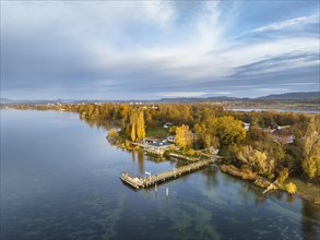 Aerial view of the Mettnau peninsula in western Lake Constance illuminated by the morning sun with the landing stage