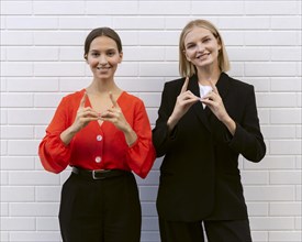 Front view smiley women using sign language