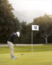 Man golf field playing flag