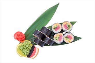 Overhead view of sushi roll with raw tuna fillet with cucumber served on bamboo leaves
