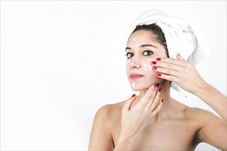 Beauty young woman applying cream face isolated white backdrop