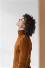 Curly man with brown blouse posing 4