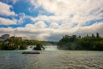 Rhine Falls and Swiss Flag with the Castle Laufen and Tourist Boat at Neuhausen in Schaffhausen