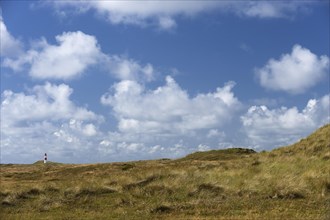 Dune landscape and lighthouse with blue sky at Ellenbogen