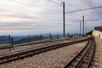 Railroad Station with Railroad Tracks with Mountainscape in a Sunny Day in Monte Generoso