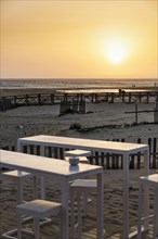 White tables and chairs in the sand