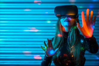 Young woman wearing virtual reality glasses touching screen with hands in an futuristic night space