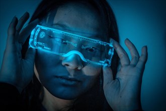 Studio photo with blue background with neon lights of a beautiful young chinese woman wearing futuristic glasses