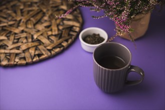 Black tea with herbs coaster purple background