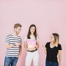 Happy man woman pointing their friend holding instagram icon