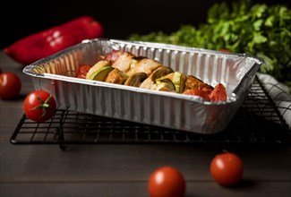 High angle chicken skewers tray with red pepper cherry tomatoes