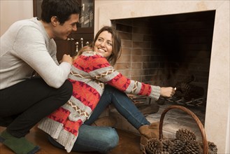 Man looking young woman ignite big match fireplace