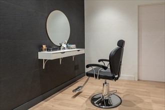Interior minimalist space of a beauty salon with a chair and a mirror