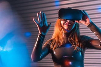 Happy futuristic woman submerged in metaverse reality by using VR goggles