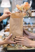 Shop assistant giving croissant bag