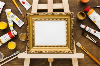 Empty canvas golden frame paint flat lay