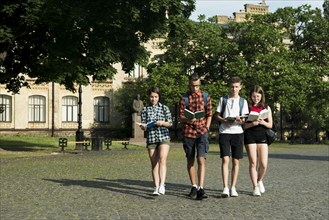 Group highschool students reading while walking