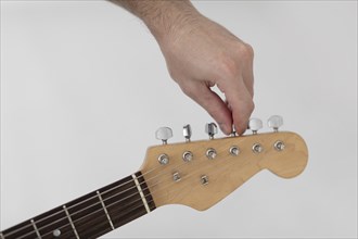 Male musician tuning electric guitar