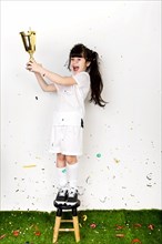 Football concept with girl celebrating with trophy