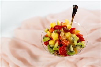 Fresh summer fruit salad on a white background